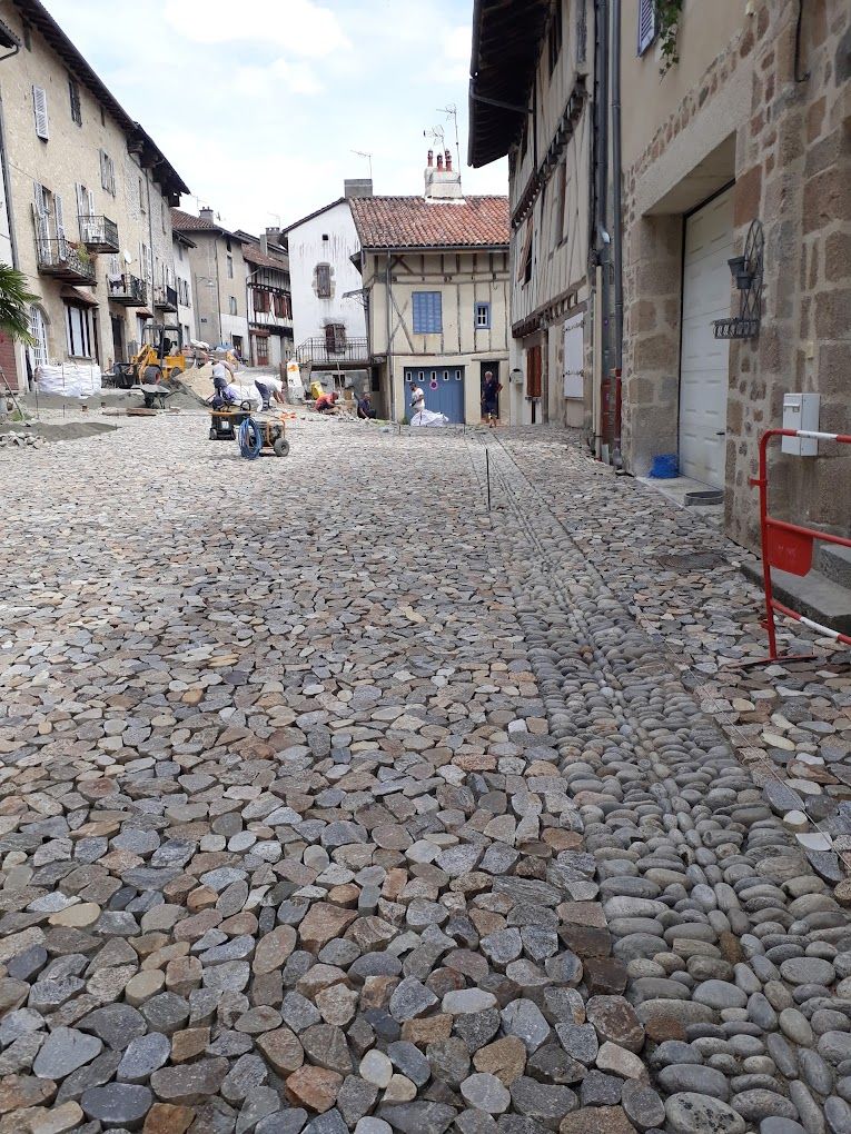 Galets en cours de pose dans une rue par l'entreprise Loreto Pavage basée à Saint-Flour dans le Cantal